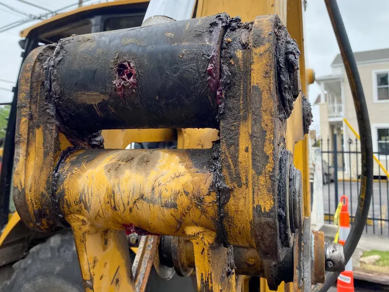 A bucket pin on a loader, caked with grease and taconite dust