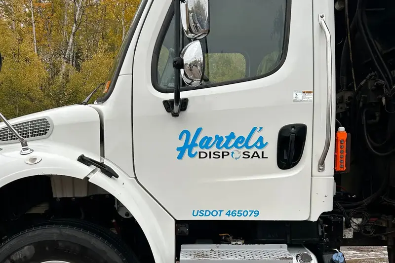 A refuse truck cab washed on site, with the customer's name clean on the door
